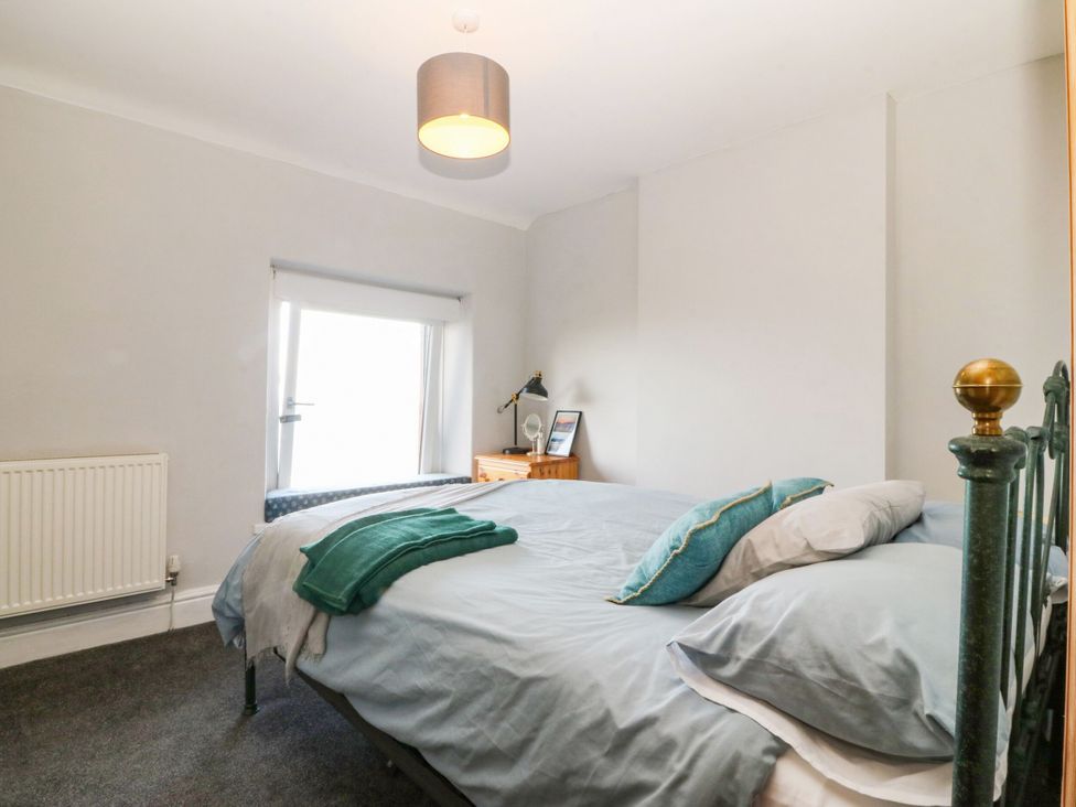 A bedroom with a bed and window at Derwen-Las in Penmaenmawr