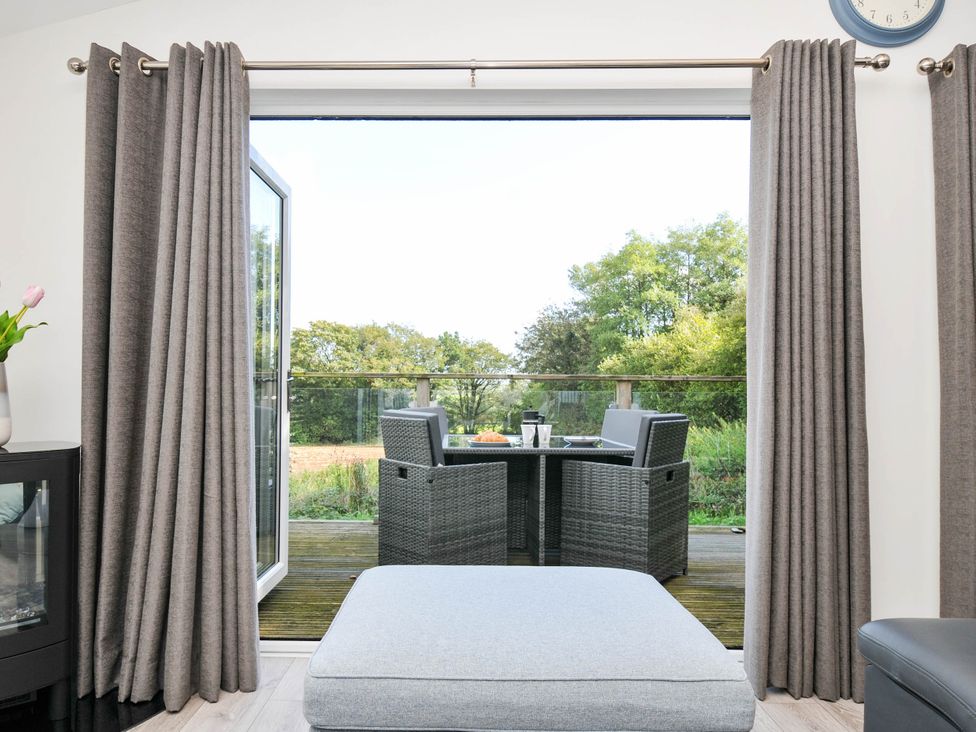 A living room with a view of an outdoor seating area at 22 Meadow Retreat in Dobwalls