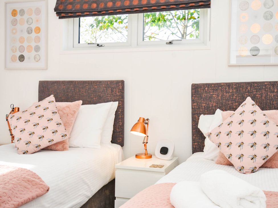 A bedroom with two beds and decorative pillows at 22 Meadow Retreat, Dobwalls