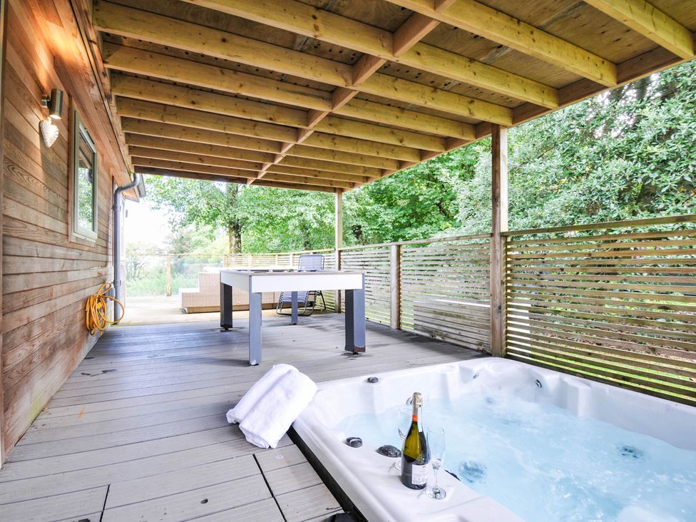 An outdoor area with a hot tub and table at 22 Meadow Retreat in Dobwalls