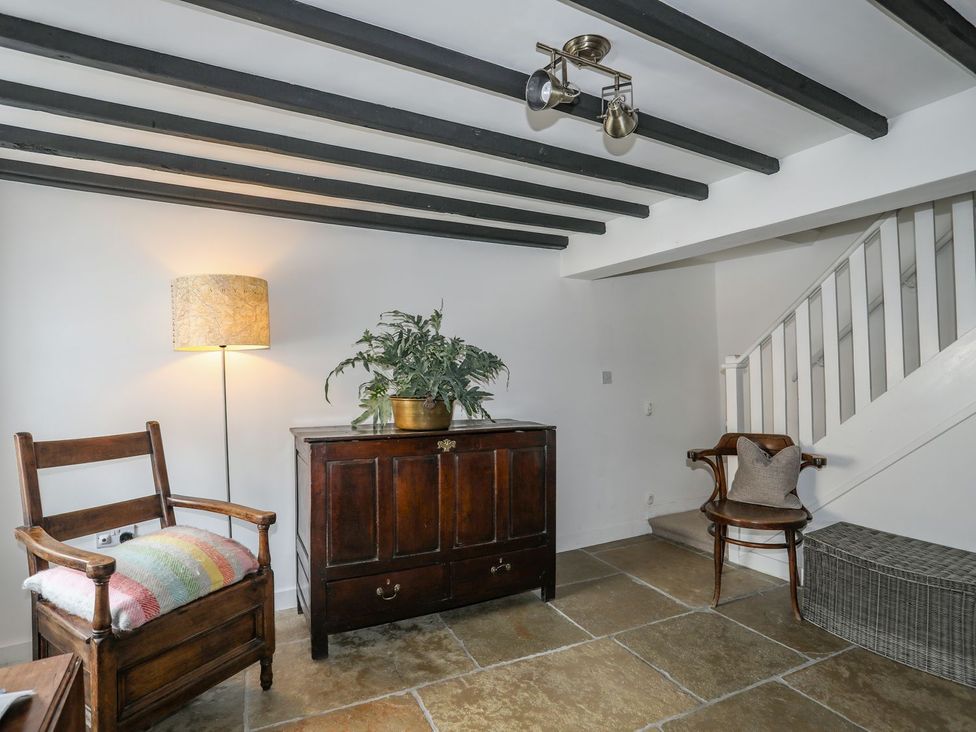 An entryway with a chest of drawers and a chair at Swn y Mor (Wexham), Beaumaris