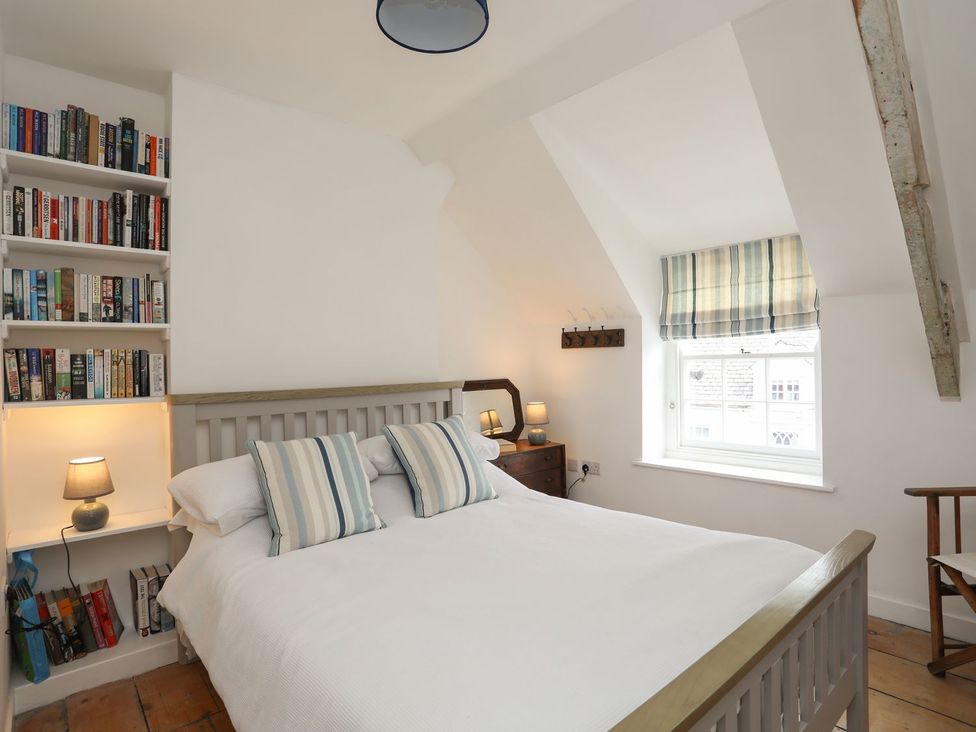 A bedroom with a bed and bookshelf at Swn y Mor (Wexham) Beaumaris