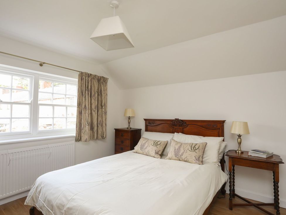 A bedroom with a bed and side table at Swn y Mor (Wexham) Beaumaris