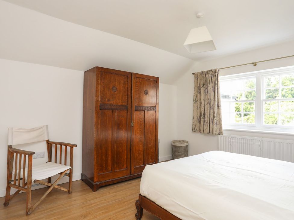 A bedroom with a wardrobe and bed at Swn y Mor (Wexham) Beaumaris