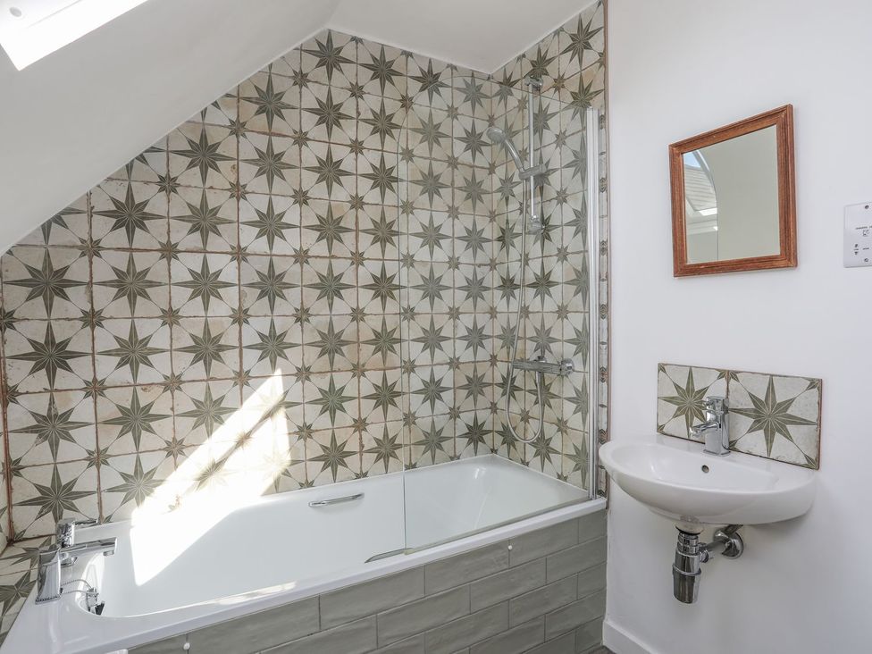 A bathroom with a bathtub and shower at Swn y Mor (Wexham) Beaumaris