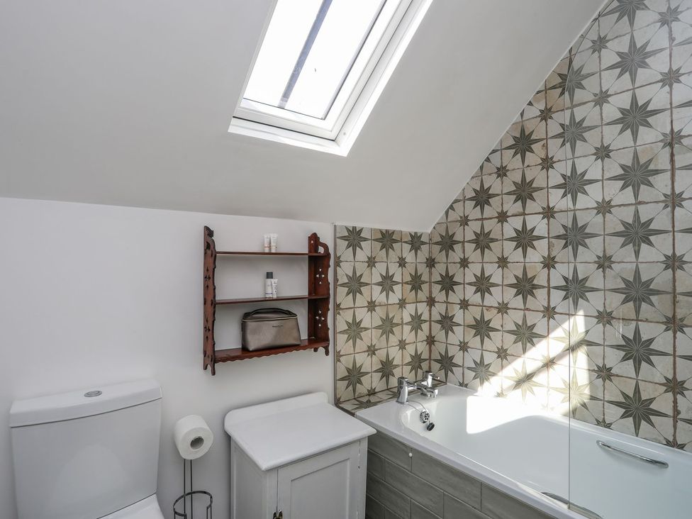 A bathroom with a bathtub and a toilet at Swn y Mor (Wexham) Beaumaris