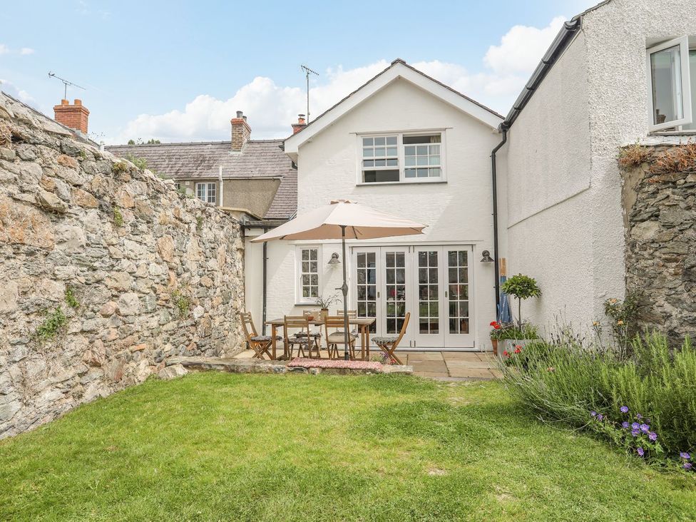 A garden with a table and chairs at Swn y Mor (Wexham) Beaumaris