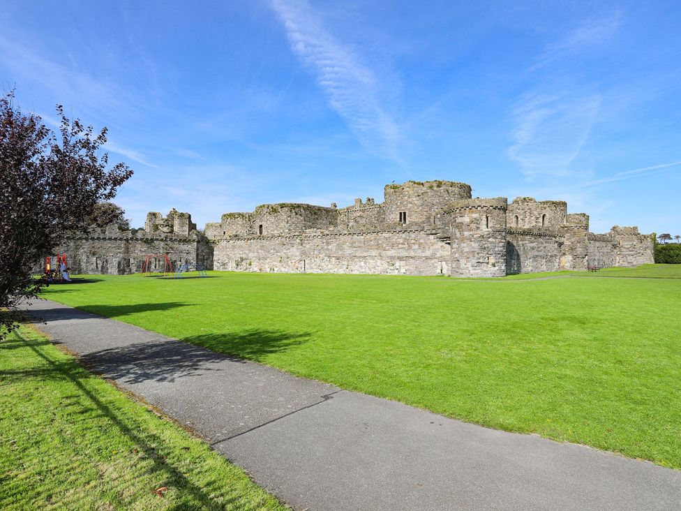 A castle with green grass and a pathway at Swn y Mor (Wexham) Beaumaris