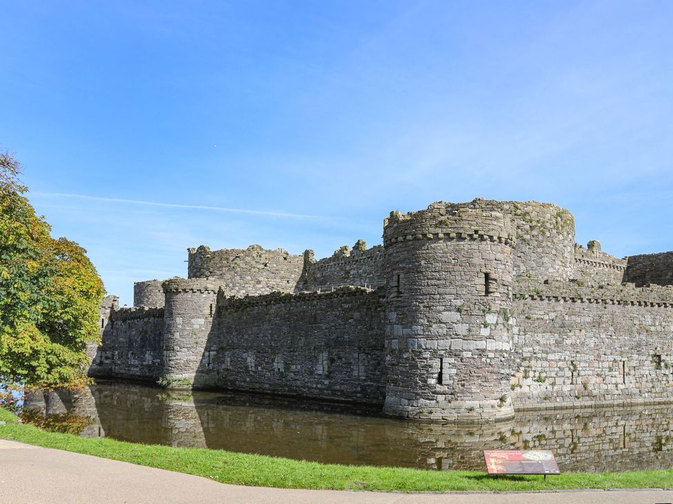 A castle with stone walls and a moat at Swn y Mor (Wexham) Beaumaris