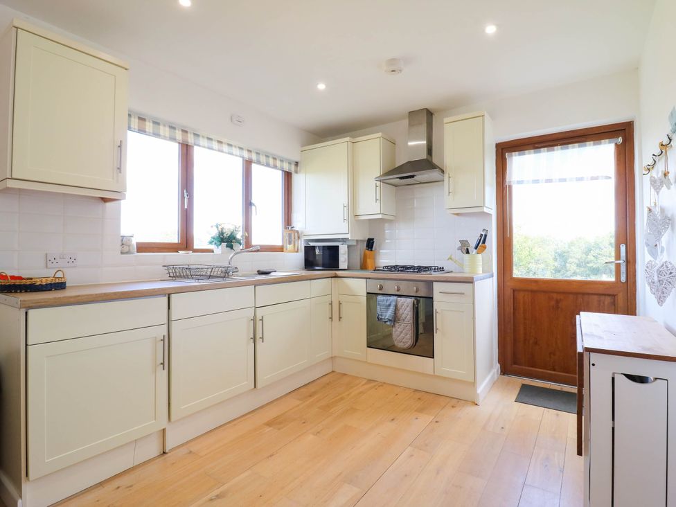 A kitchen with cabinets and appliances at Elsie Lodge in Hastings