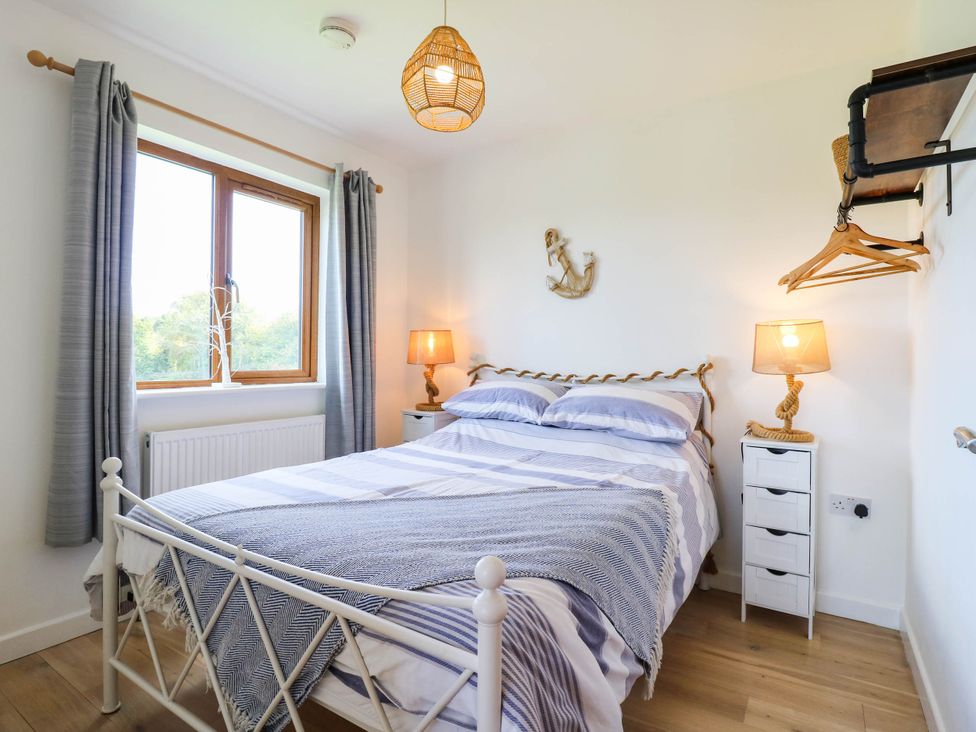 A bedroom with a bed and nightstand at Elsie Lodge Hastings