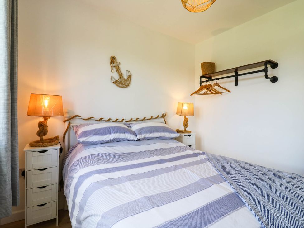 A bedroom with a bed and nightstand at Elsie Lodge in Hastings