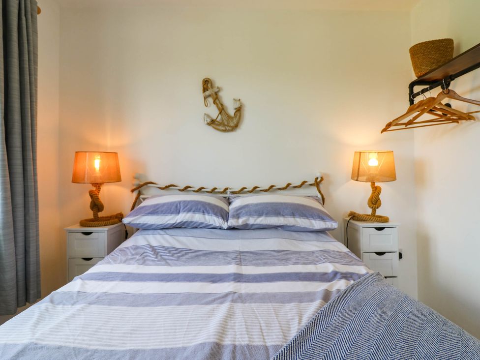 A bedroom with a bed and lamps at Elsie Lodge in Hastings