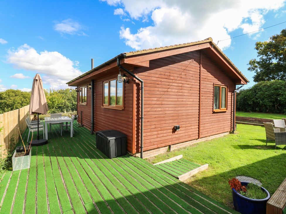 An outdoor area with a wooden house and deck at Elsie Lodge in Hastings