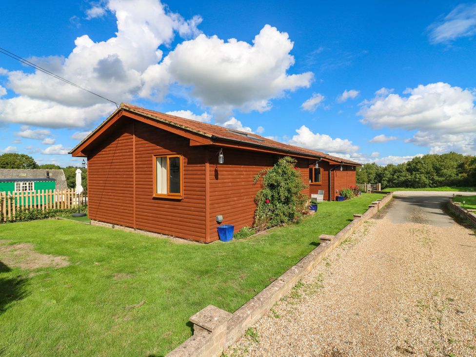 A cabin with a driveway and garden at Rosie Lodge in Hastings