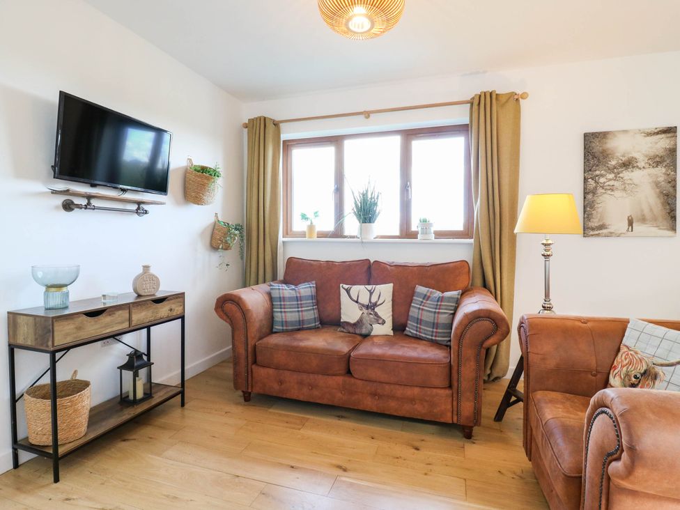 A living room with a sofa and a television at Rosie Lodge in Hastings