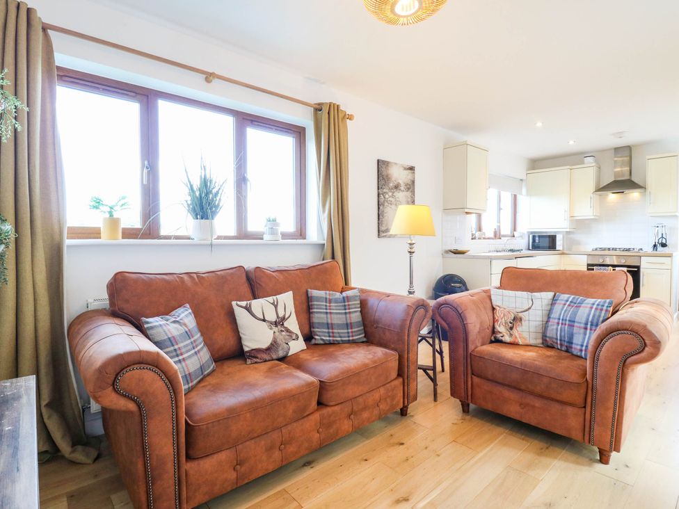 A living room with a sofa and armchairs at Rosie Lodge in Hastings