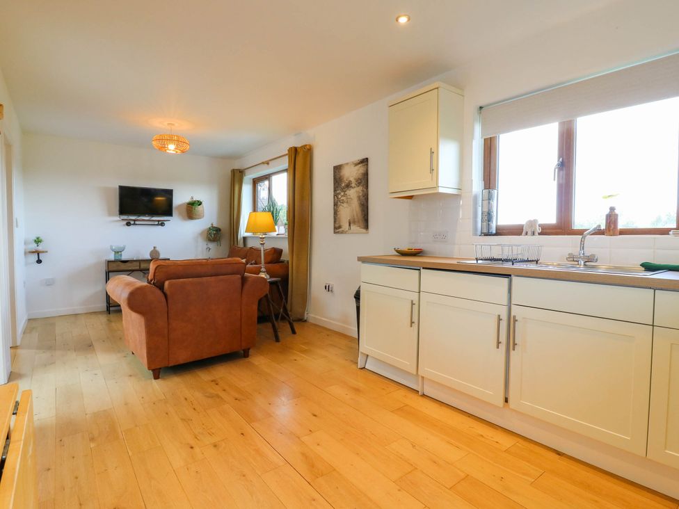 A living room with a sofa and television at Rosie Lodge in Hastings
