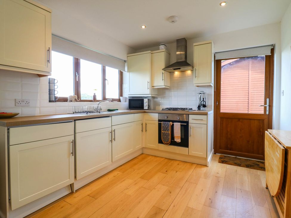 A kitchen with cabinets and appliances at Rosie Lodge in Hastings