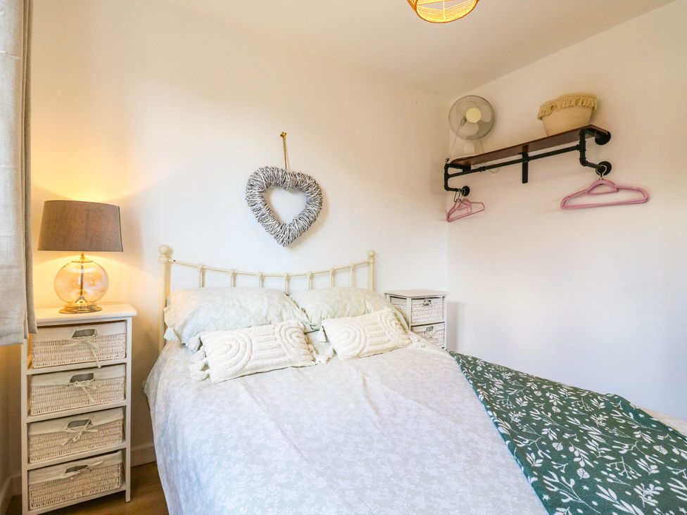 A bedroom with a bed and a lamp at Rosie Lodge in Hastings