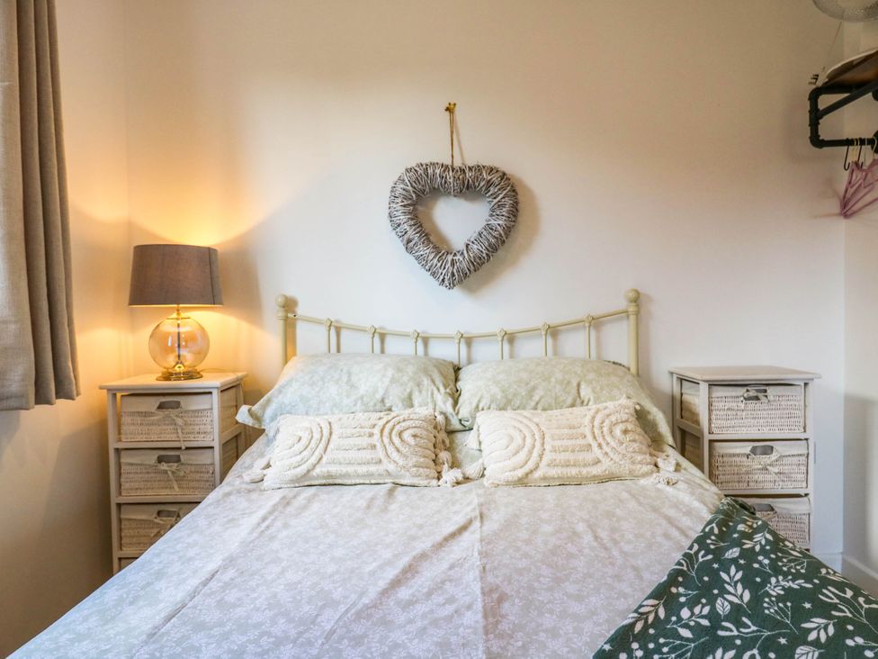 A bedroom with a bed and bedside tables at Rosie Lodge in Hastings