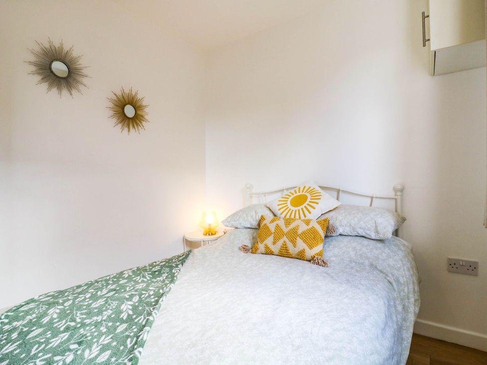 A bedroom with a bed and lamp at Rosie Lodge in Hastings