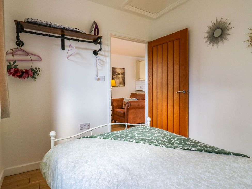 A bedroom with a bed and shelf at Rosie Lodge in Hastings