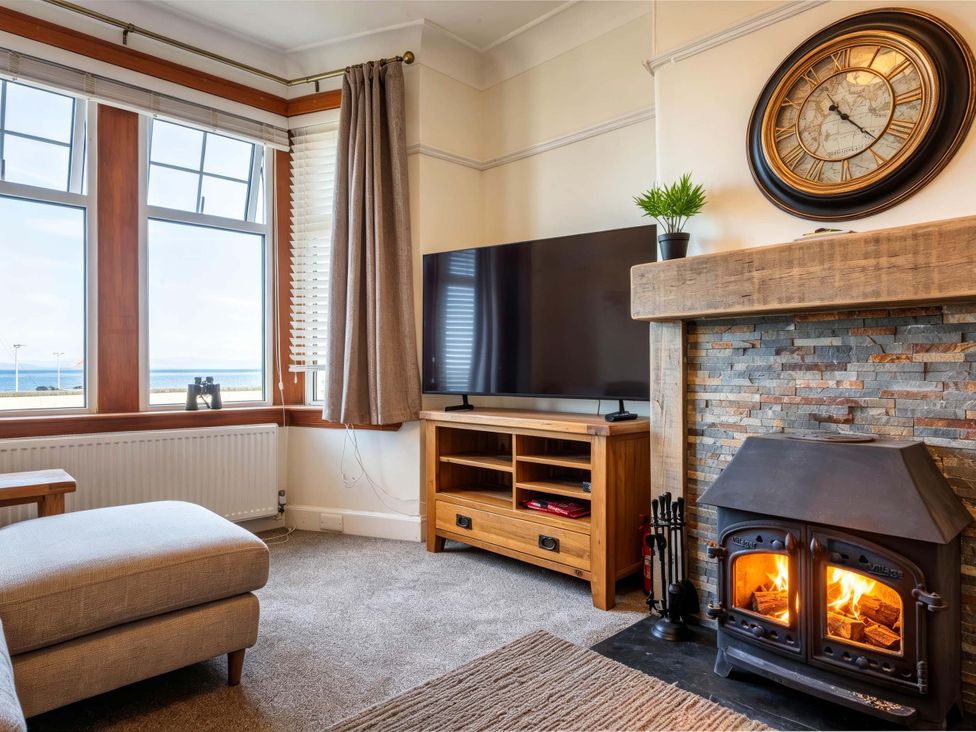 A living room with a television next to a fireplace at Fereneze, Lochranza, Isle Of Arran