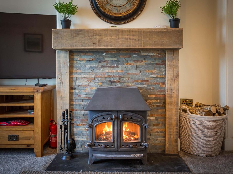 A living room with a fireplace and tv at Fereneze, Lochranza, Isle Of Arran