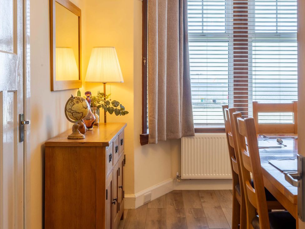 A dining room with a console table and lamp at Fereneze, Lochranza, Isle Of Arran