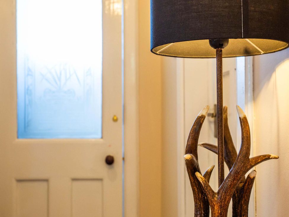 An entrance hall with a lamp and door at Fereneze, Lochranza, Isle Of Arran