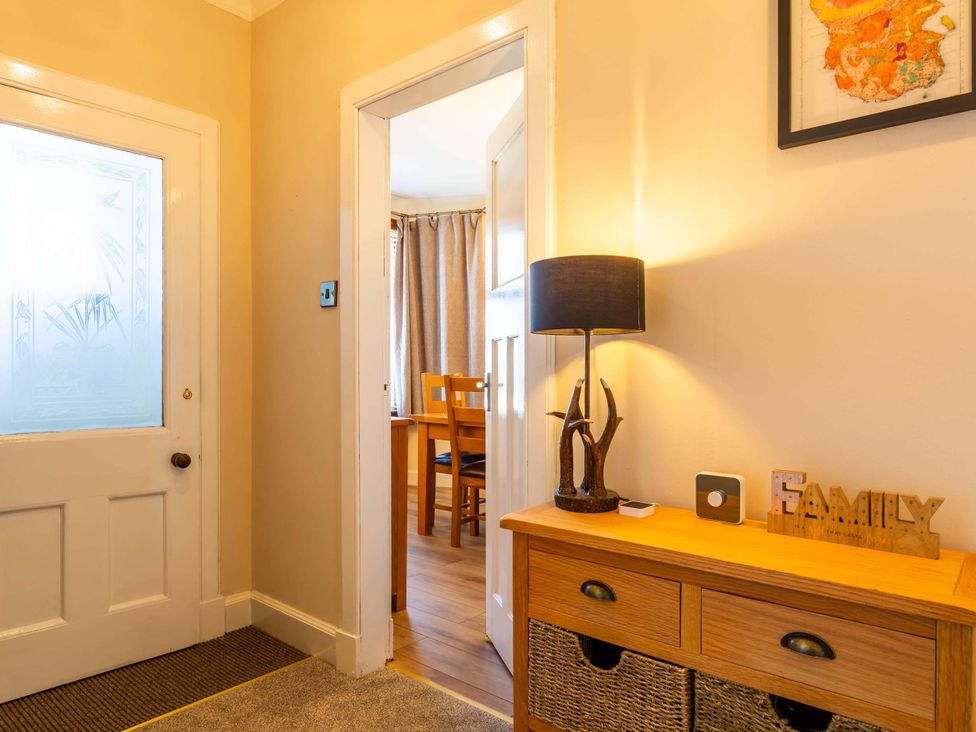 A hallway with a door and lamp at Fereneze, Lochranza, Isle Of Arran
