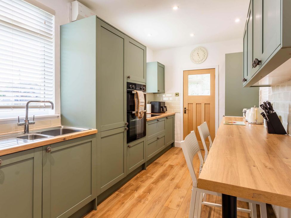 A kitchen with wooden counter and fitted appliances at Fereneze in Lochranza, Isle Of Arran