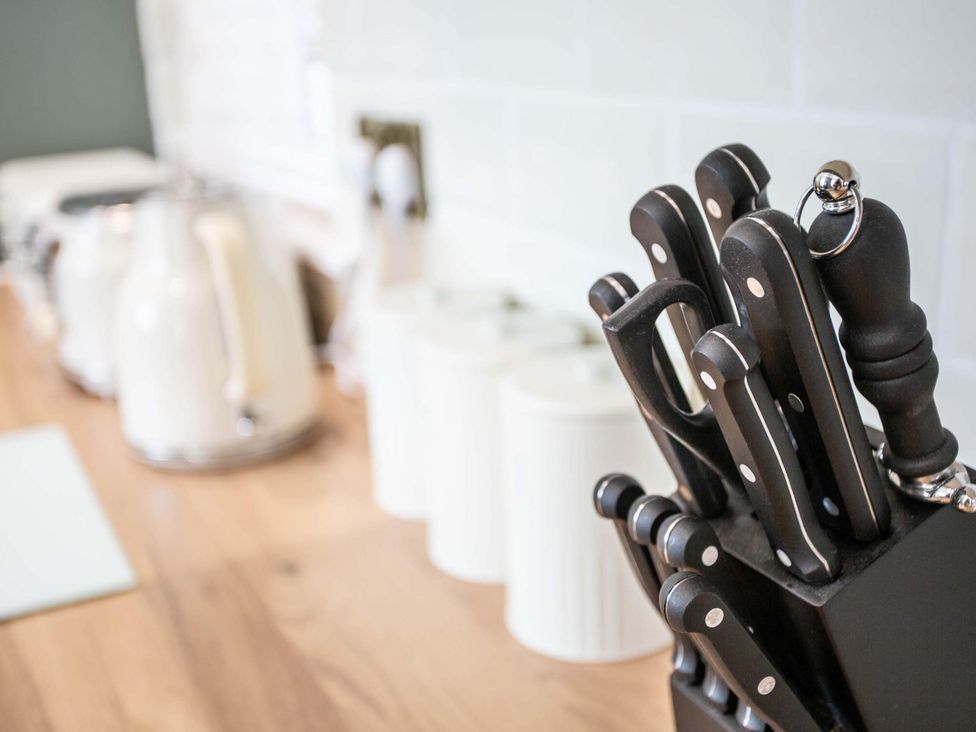 A kitchen with knives in a block and a kettle at Fereneze, Lochranza, Isle Of Arran