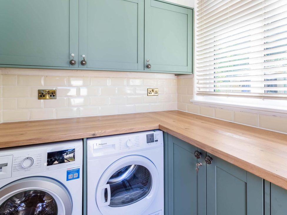 A laundry room with a washing machine and dryer at Fereneze, Lochranza, Isle Of Arran