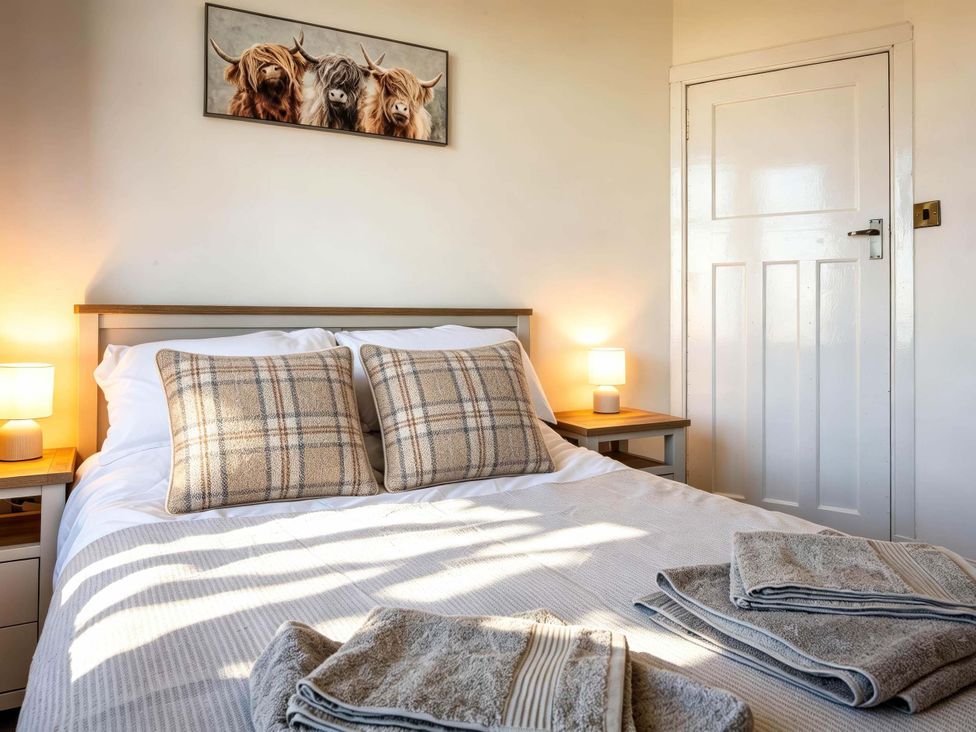 A bedroom with a bed and bedside table at Fereneze, Lochranza, Isle Of Arran