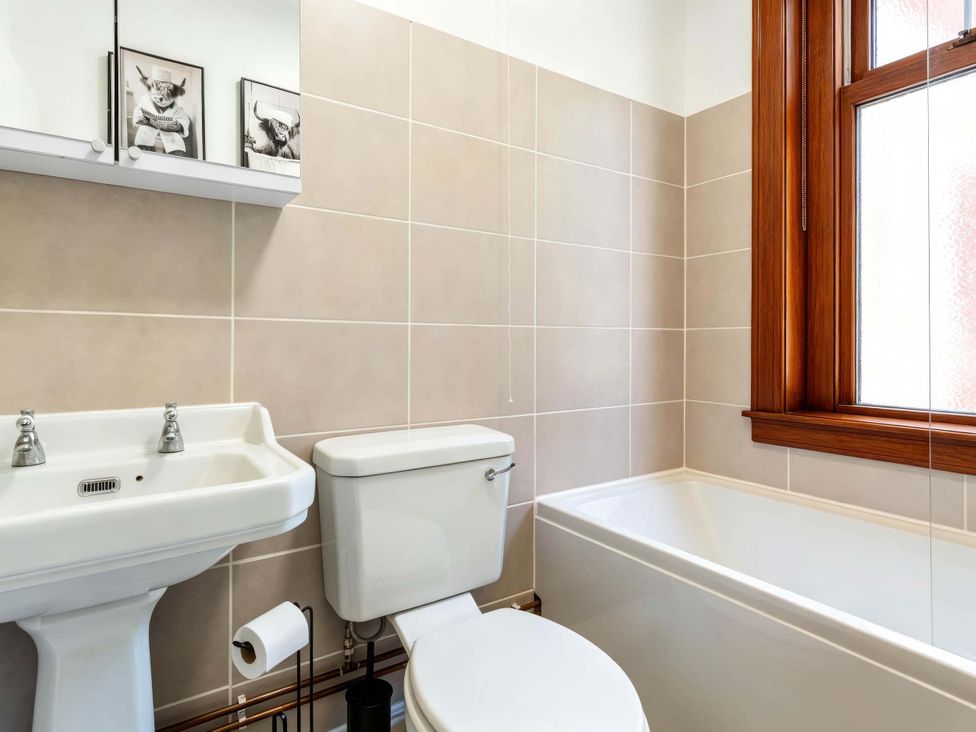 A bathroom with sink, toilet, bathtub and window at Fereneze, Lochranza, Isle Of Arran