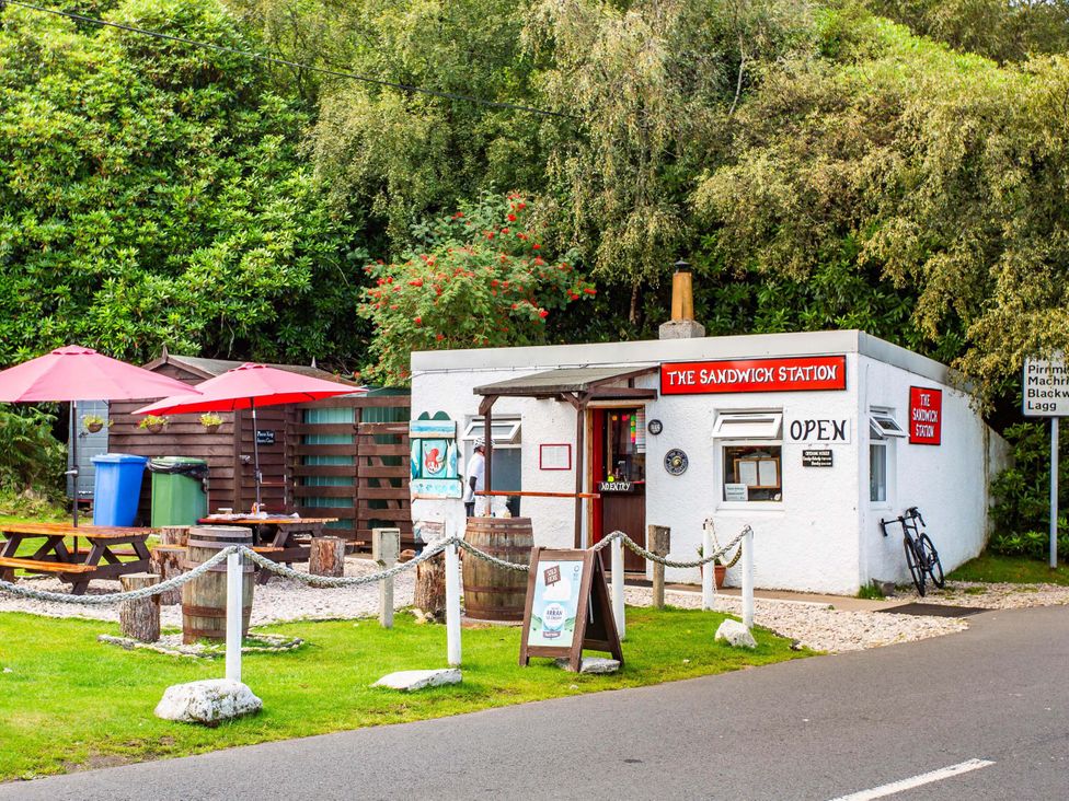 An outdoor building with seating and a sign at The Sandwich Station in Lochranza, Isle Of Arran