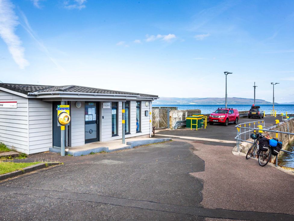 A parking area with a building and cars at Fereneze, Lochranza, Isle Of Arran