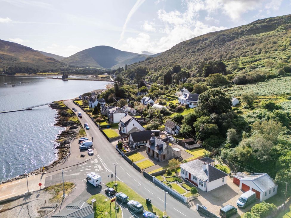 An aerial view of houses along a waterfront at Fereneze, Lochranza, Isle Of Arran