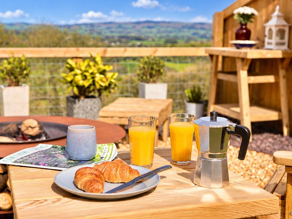 An outdoor dining area with food and drinks at Oak Hut in Bishops Castle