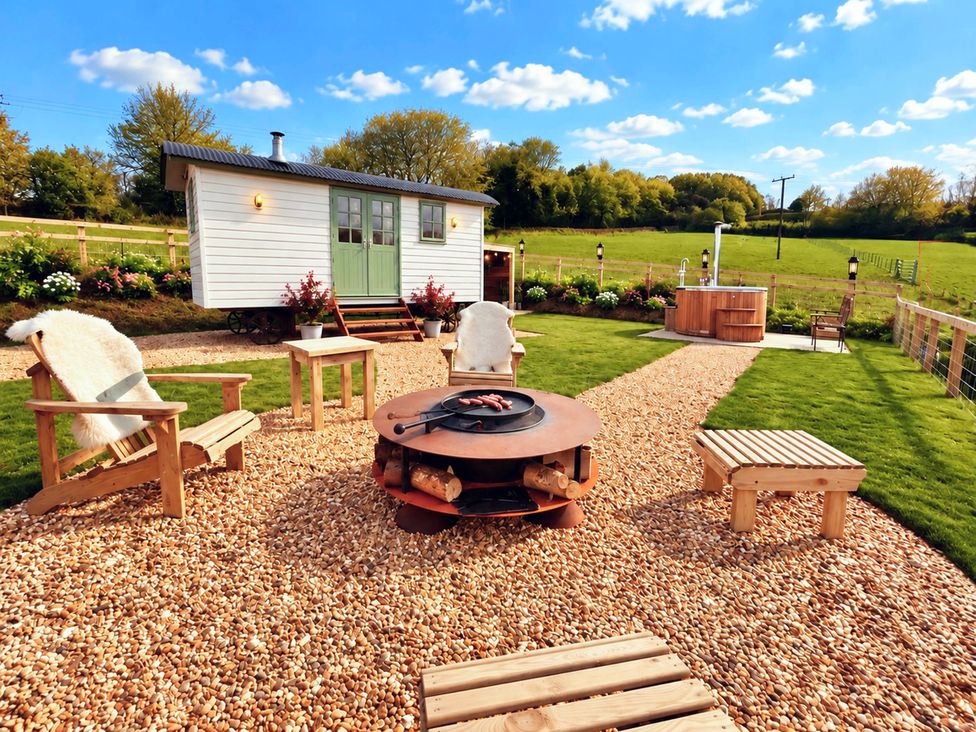 A garden with seating and a fire pit at Oak Hut in Bishops Castle