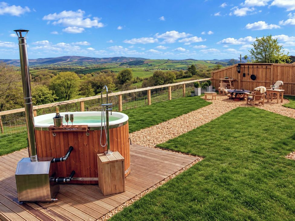An outdoor area with hot tub and seating at Oak Hut in Bishops Castle
