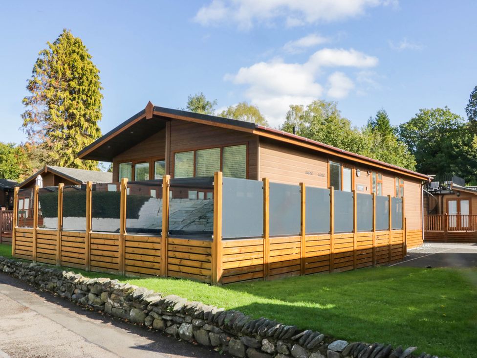 A house surrounded by a wooden fence and trees at Thirlmere Scar in Troutbeck Bridge