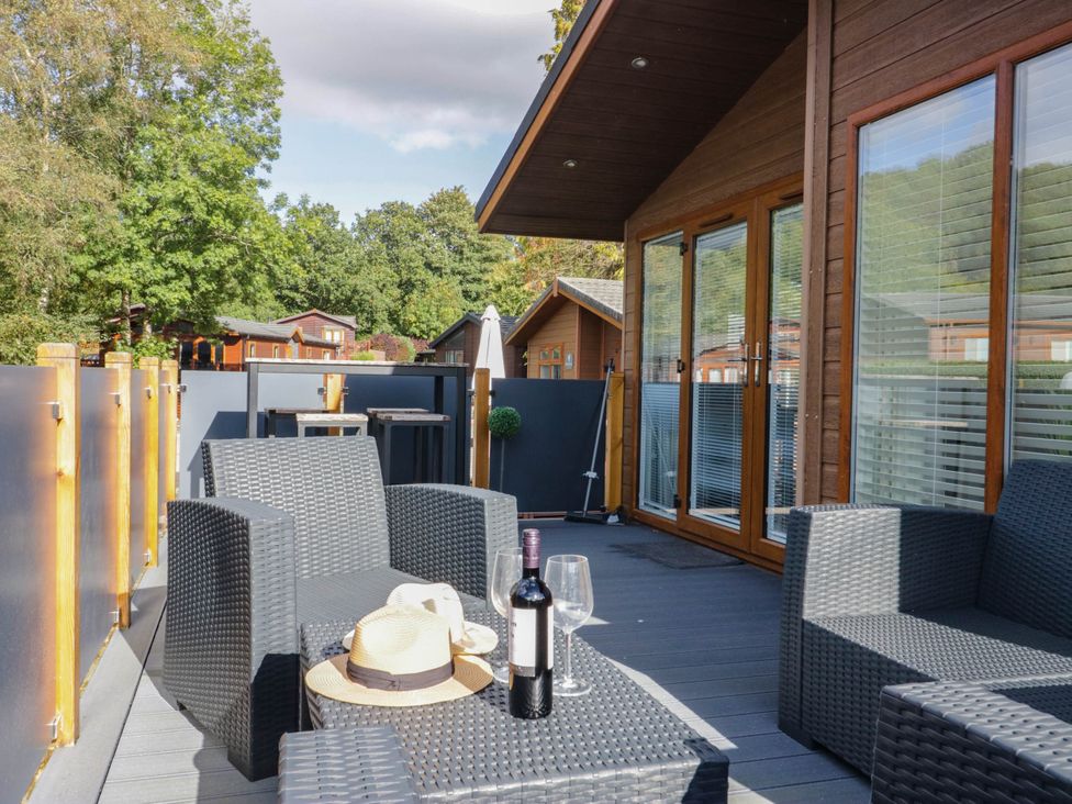 A deck with outdoor furniture and wine at Thirlmere Scar in Troutbeck Bridge