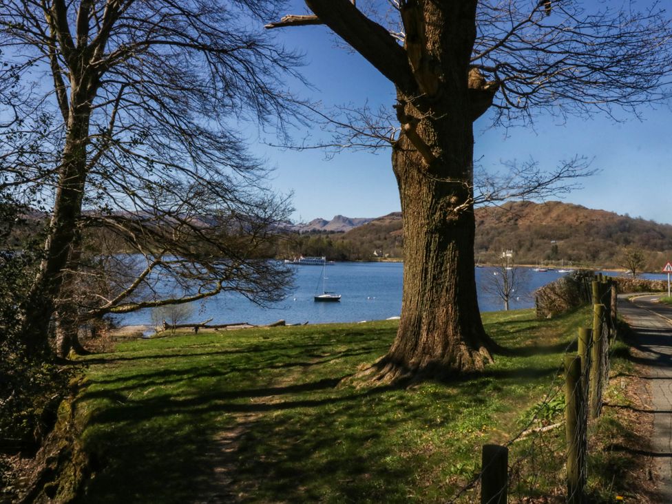 A view of a lake with a tree and a boat at Thirlmere Scar in Troutbeck Bridge
