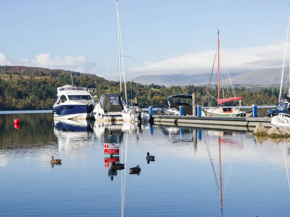 Boats moored at a pier with ducks in the water at Thirlmere Scar Troutbeck Bridge