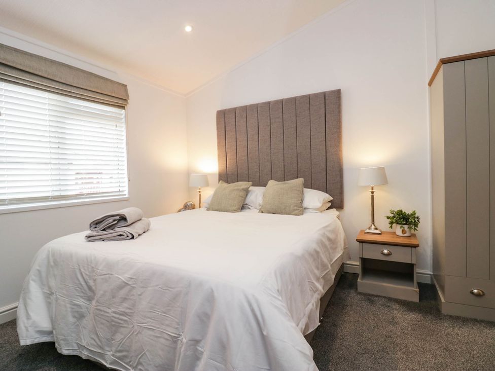 A bedroom with a bed and side tables at Thirlmere Scar Windermere