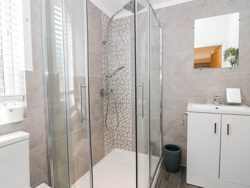A bathroom with a shower, toilet, and sink at Thirlmere Scar in Windermere