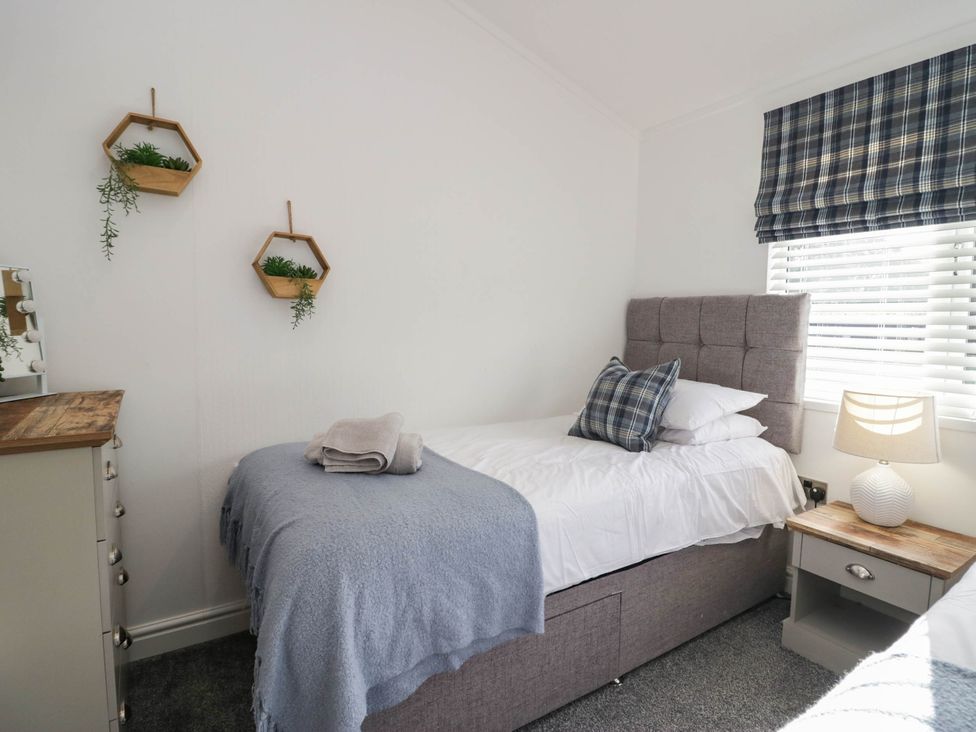 A bedroom with a single bed and nightstand at Thirlmere Scar in Windermere